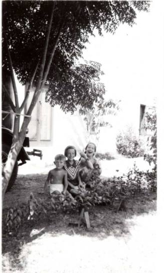 Bill and JoAnne Raymond with Jo Ann Dewey Behind Shrubs
