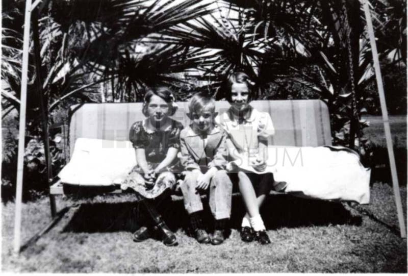 Joann Dewey, Bill and JoAnn Raymond on a Swing