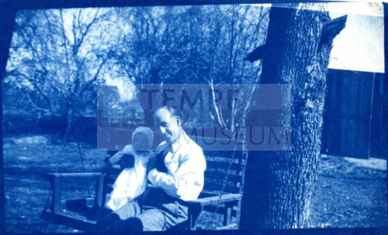 Bill Laird Holds Child on a Bench