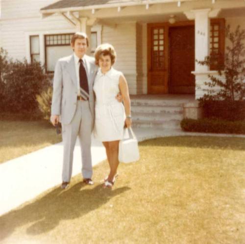 William Raymond Stands Outside a House with a Woman