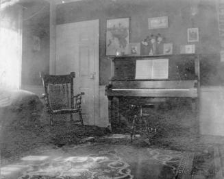 Interior showing Rocking Chair and Piano with photographs on wall