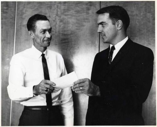 Photograph - 2 Men Exchanging Document