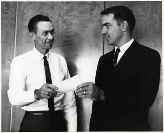 Photograph - 2 Men Exchanging Document