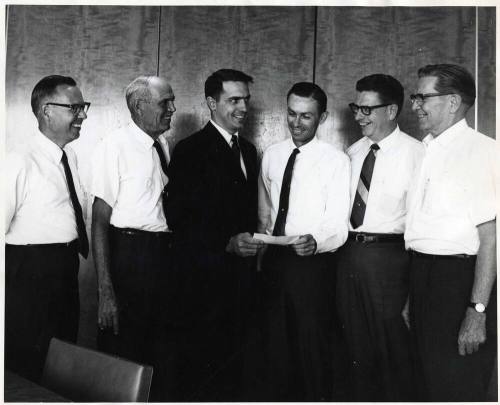 Photograph - 6 Men Gathered Exchanging Document