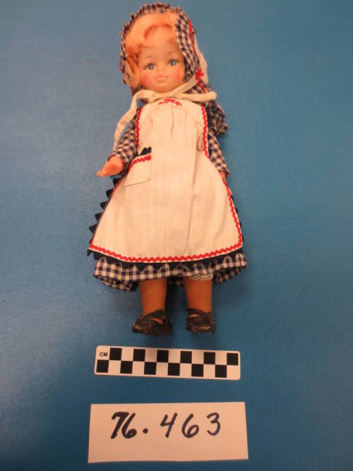 Doll wearing housedress with apron and bonnet