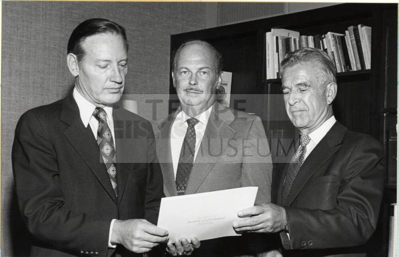 President Schwada and Two Men View Proclamation