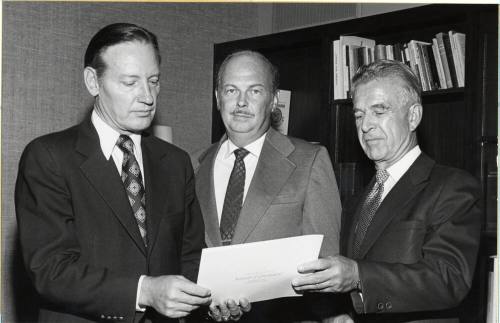 President Schwada and Two Men View Proclamation