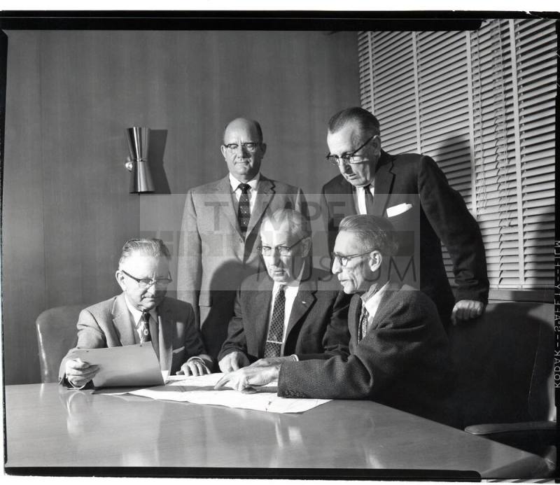 Group of Five Men Looking at Papers