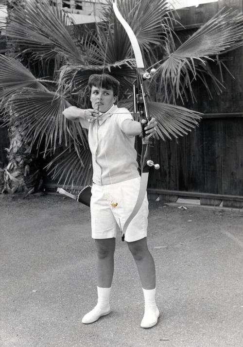 Judy Severance poses with a drawn bow