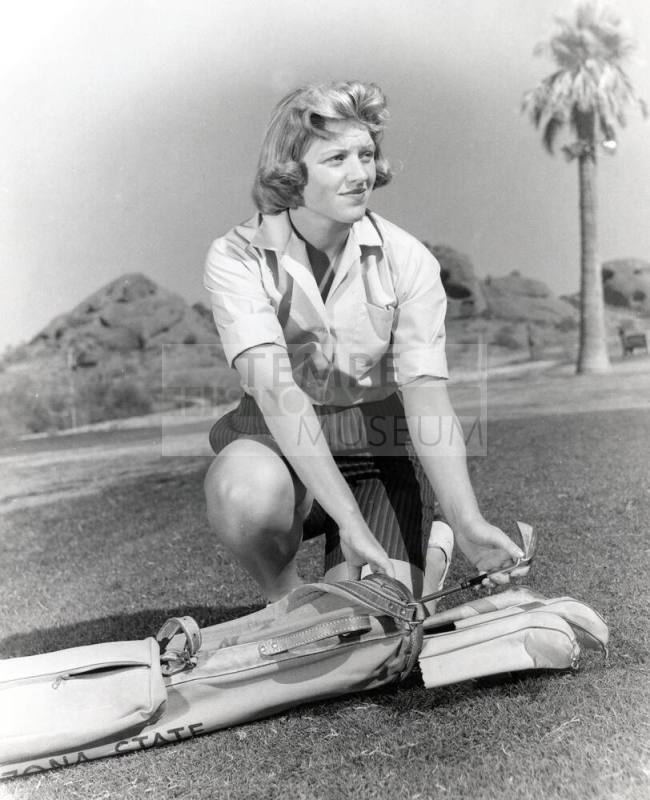 This black and white photo shows JoAnne Gunderson Carner removing a club from her golf bag.