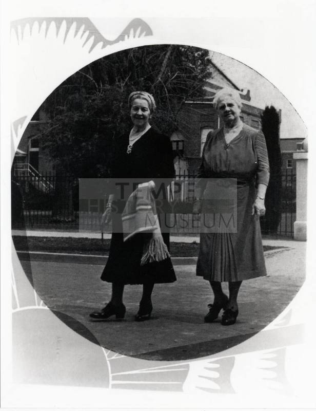 Two women in front of building on campus