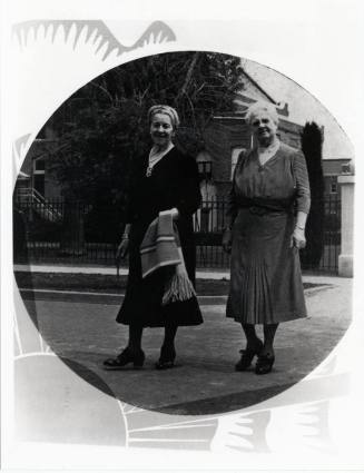 Two women in front of building on campus