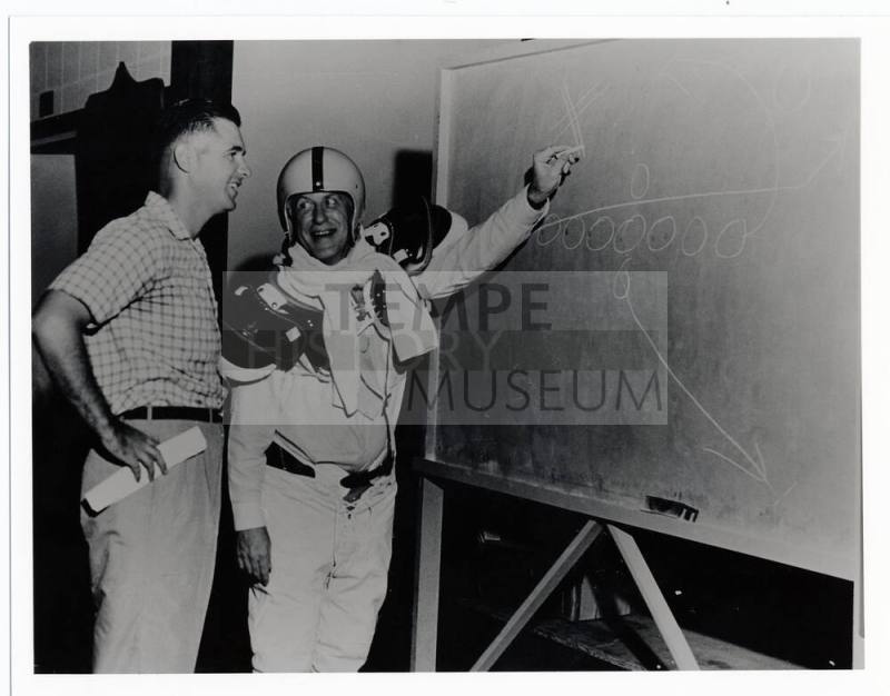 Two men with football play diagram