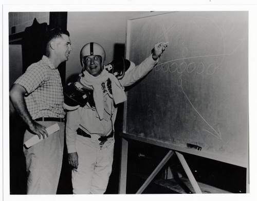 Two men with football play diagram