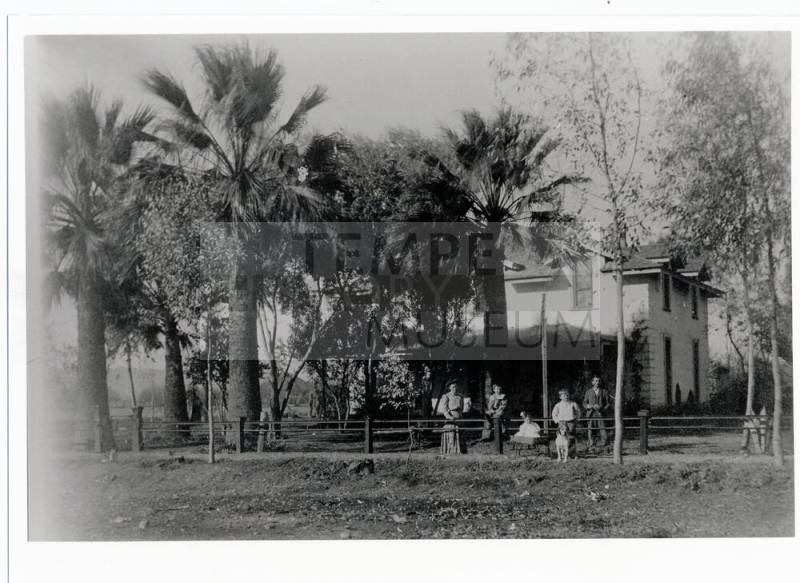 Family in front of two-story house