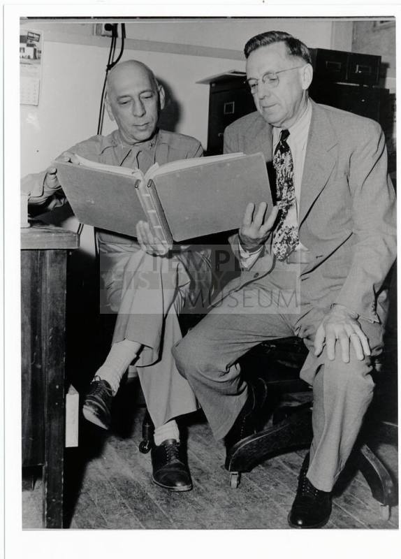 Two men looking at a book