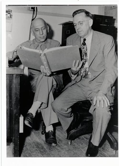 Two men looking at a book