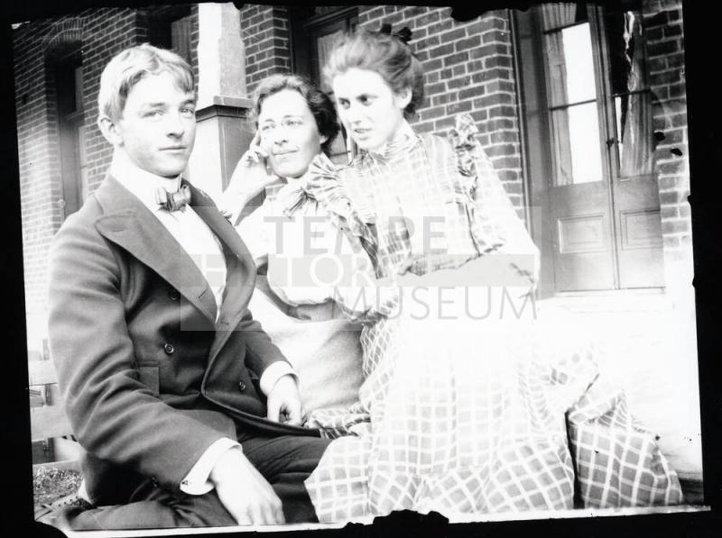 Three people sitting on a porch