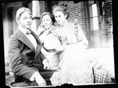 Three people sitting on a porch