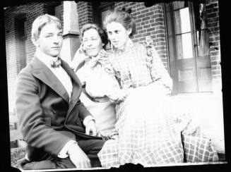 Three people sitting on a porch
