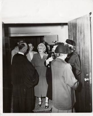 Photograph of  Reverend Prior greeting parishiners in doorway of First Congregational Church of Tempe