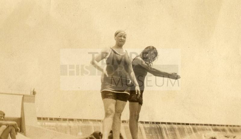 Two women in swim suits stand near Granite Reef Dam