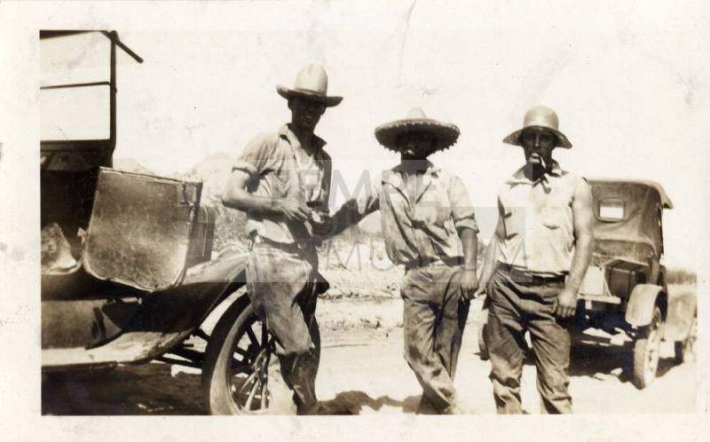 Prisoners standing by a car