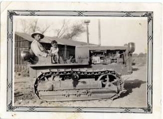 Ray Rodriguez and Ray, Jr. sit on a Catapillar machine