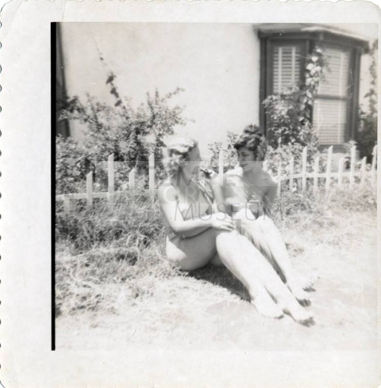 Two women visiting in a yard
