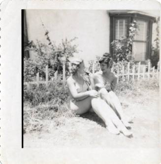 Two women visiting in a yard