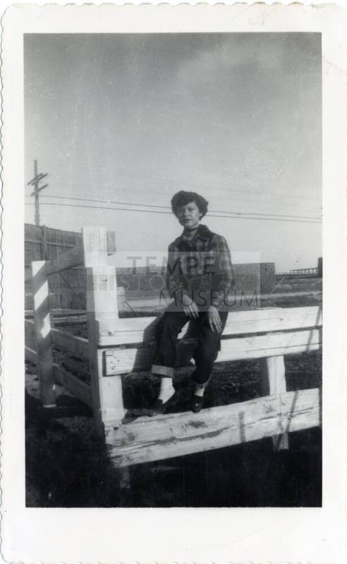 Genevieve Puerta sitting on wooden fence