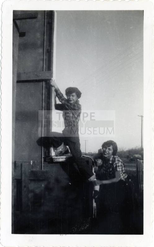 Marcie Rodriguez and and friend climbing on a sign