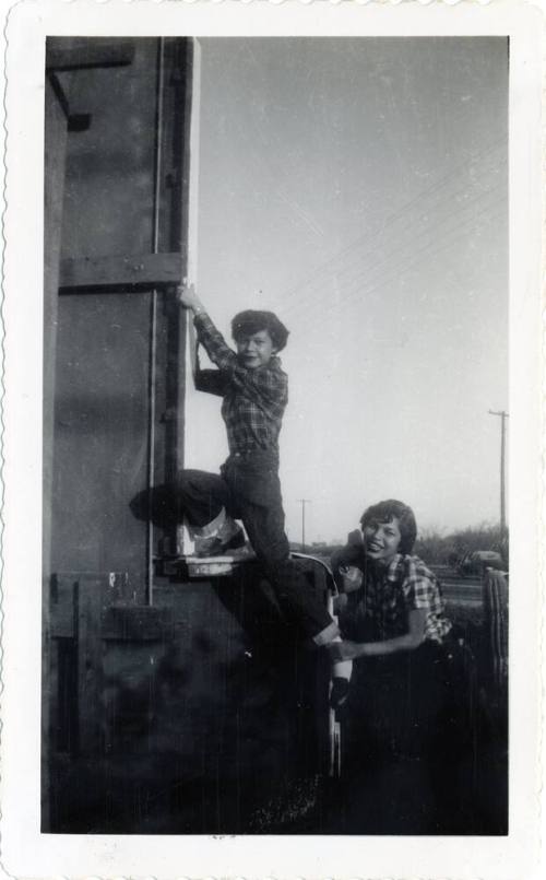 Marcie Rodriguez and and friend climbing on a sign