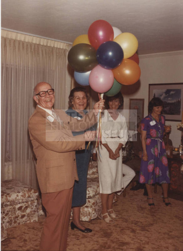 Howard Pyle Holding Balloons at Party