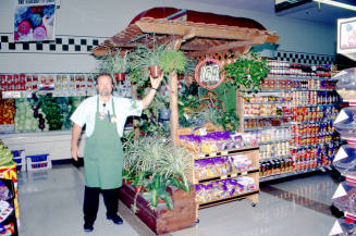 Store employee with plants in Stabler's Market, University Dr. and Mill Ave.