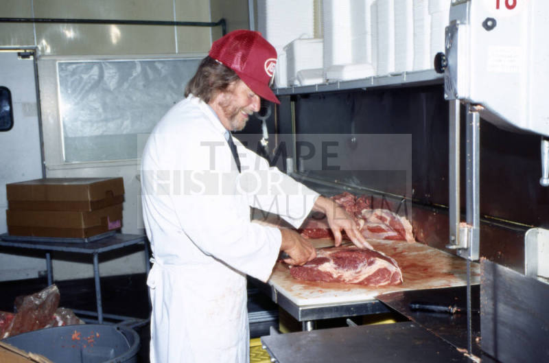 Employee in meat department, Stabler's Market, University Dr. and Mill Ave.