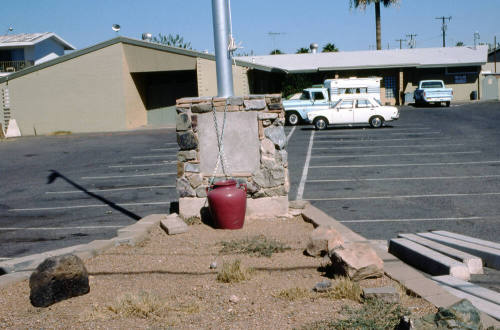 Unknown Brown Building with Parking Lot, Flag Pole and a Red Vase In-Front