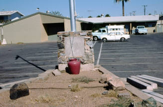 Unknown Brown Building with Parking Lot, Flag Pole and a Red Vase In-Front