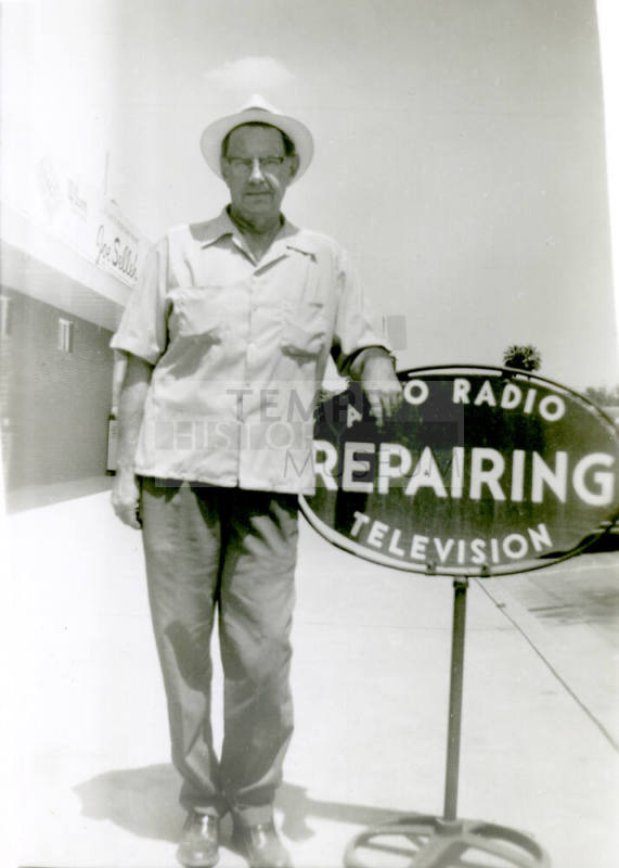 William Hertenstein by his Radio Shop sign