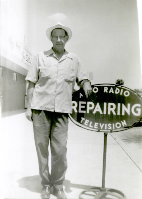 William Hertenstein by his Radio Shop sign