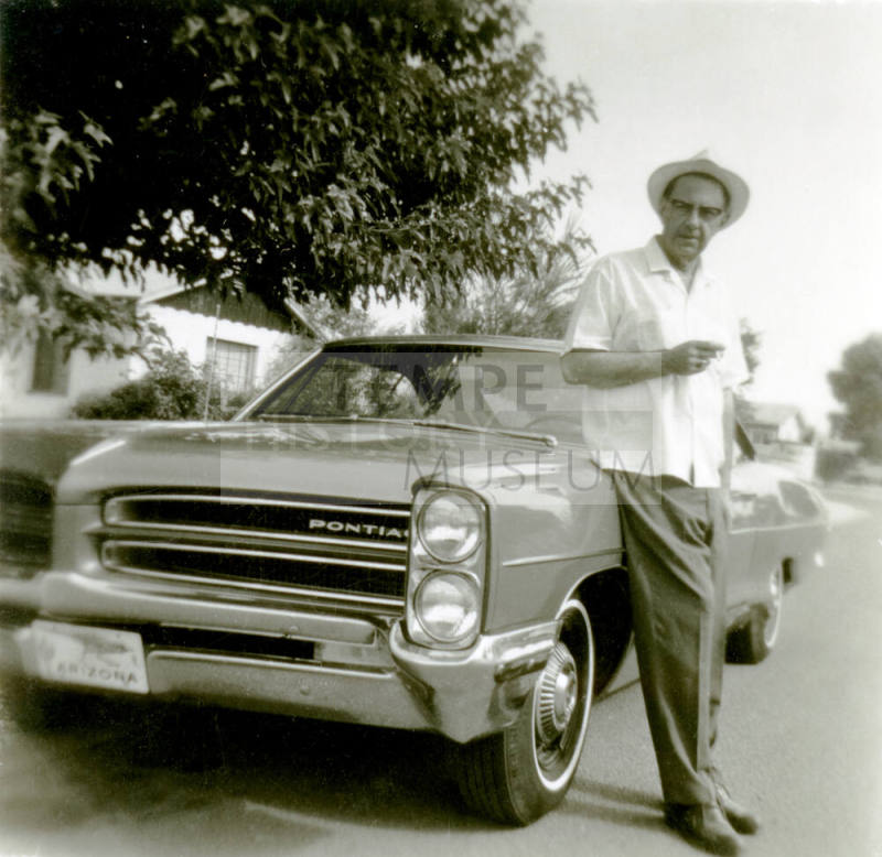 Bill Hertenstein leaning on a car