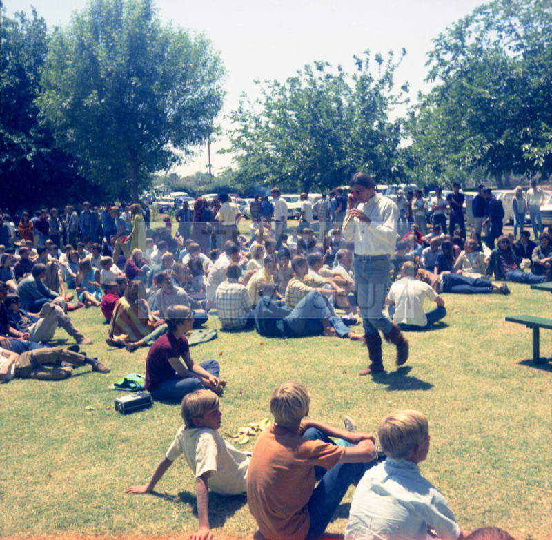 Love-in at Tempe Beach Park--people sitting on grass, 1 man standing/walking