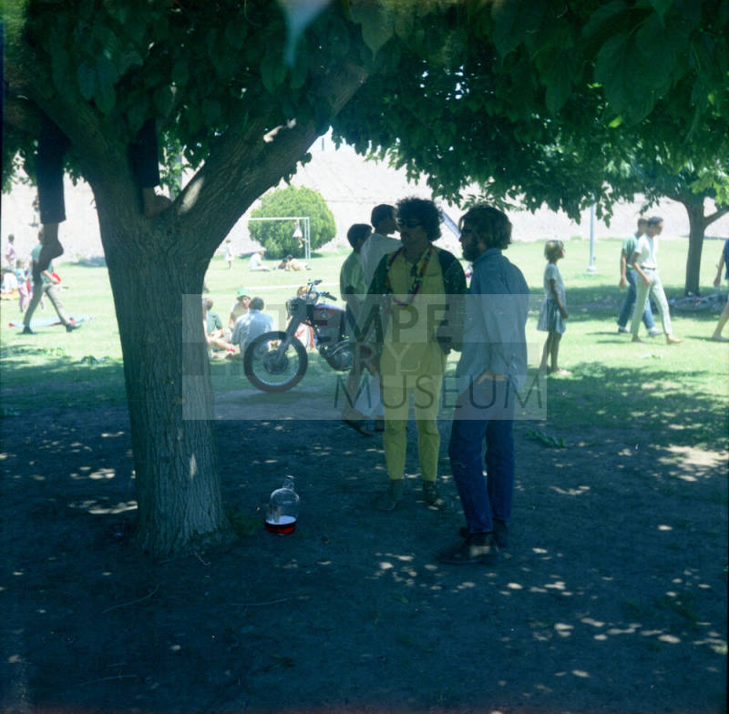 Love-in at Tempe Beach Park --2 men standing under a tree