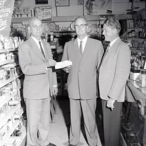 Mayor Hugh Laird Handing a Donation to 2 Men