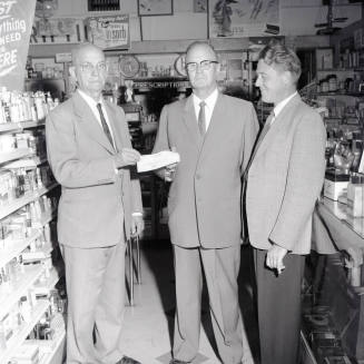 Mayor Hugh Laird Handing a Donation to 2 Men