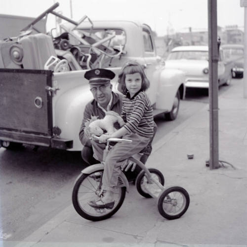 Street Scene with Young Girl on a Tricycle and Uniformed Man on Mill Avenue