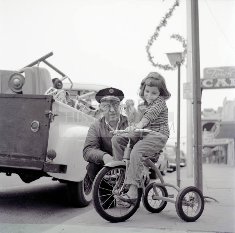 Street Scene with Young Girl on a Tricycle and Uniformed Man on Mill Avenue