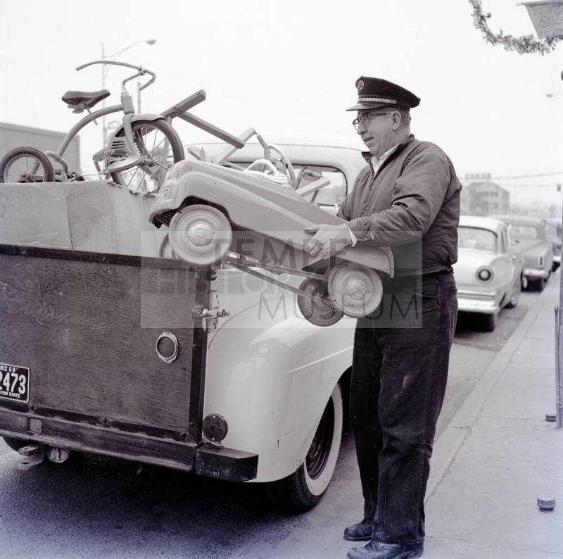 Uniformed Man Holding a Toy Car on Mill Avenue