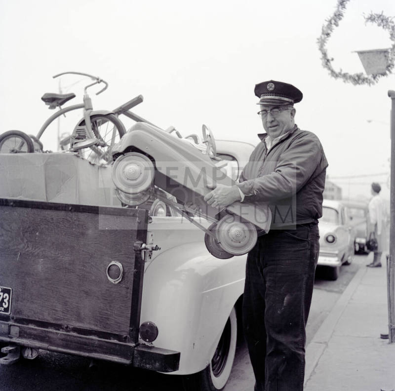 Uniformed Man Holding a Toy Car on Mill Avenue