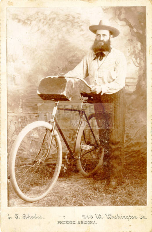 Dr. Fenn J Hart posing next to a bicycle in Phoenix, Arizona
